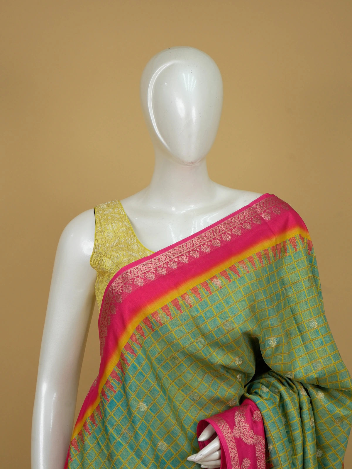 Green Dola silk saree with golden checks, contrast pink zari border and ornate orange-yellow pallu