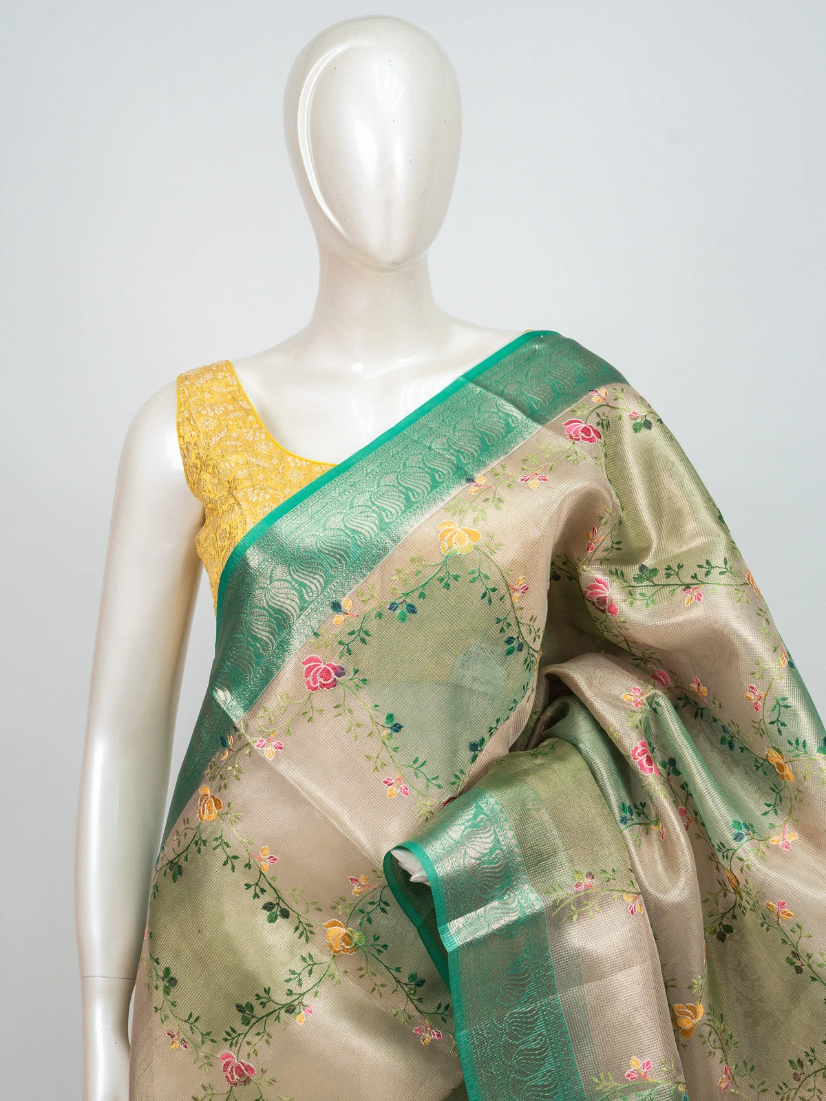 Cream and green semi raw silk saree with multicoloured floral vines and a green zari border