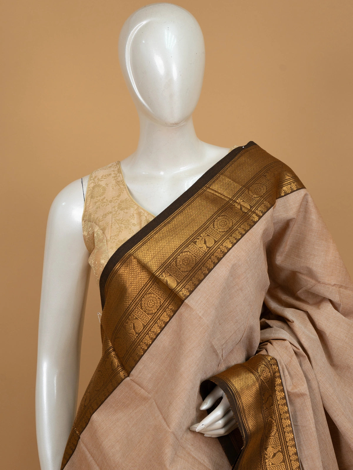 Beige Chettinad cotton saree with dark brown and gold zari peacock motif border