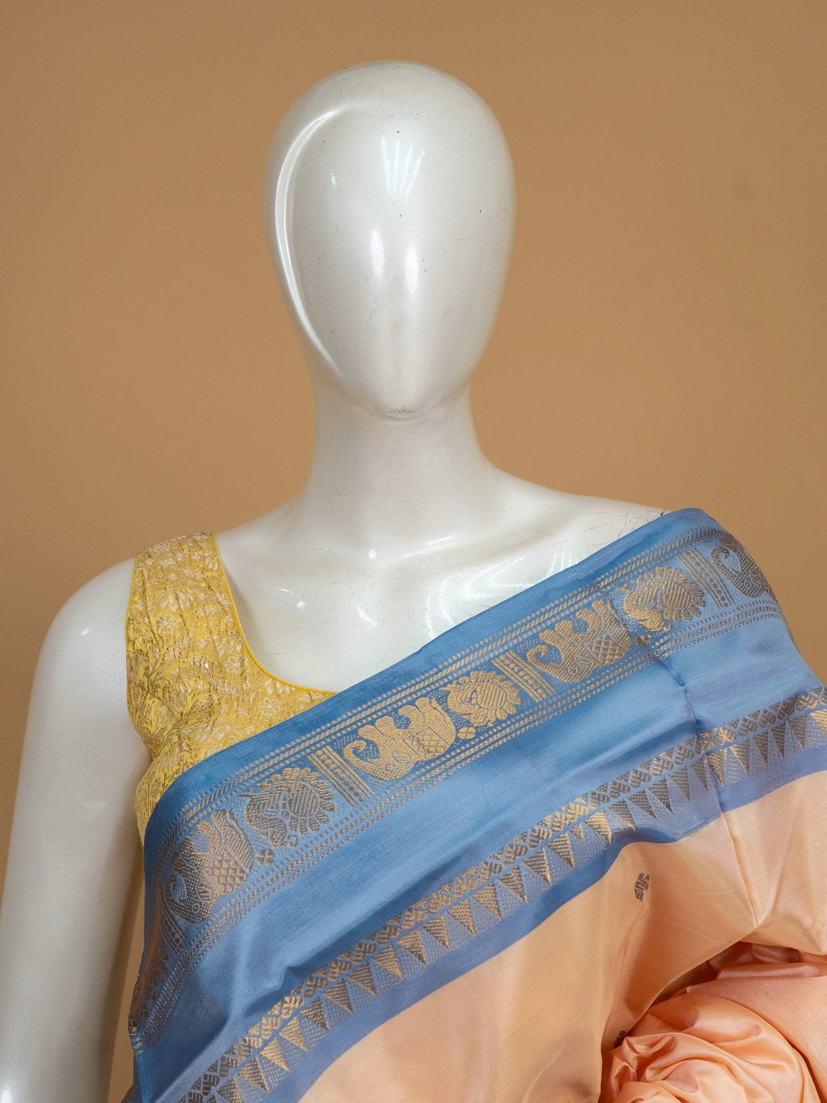 Peach banana silk saree with contrast blue zari border and elephant-peacock pallu motifs