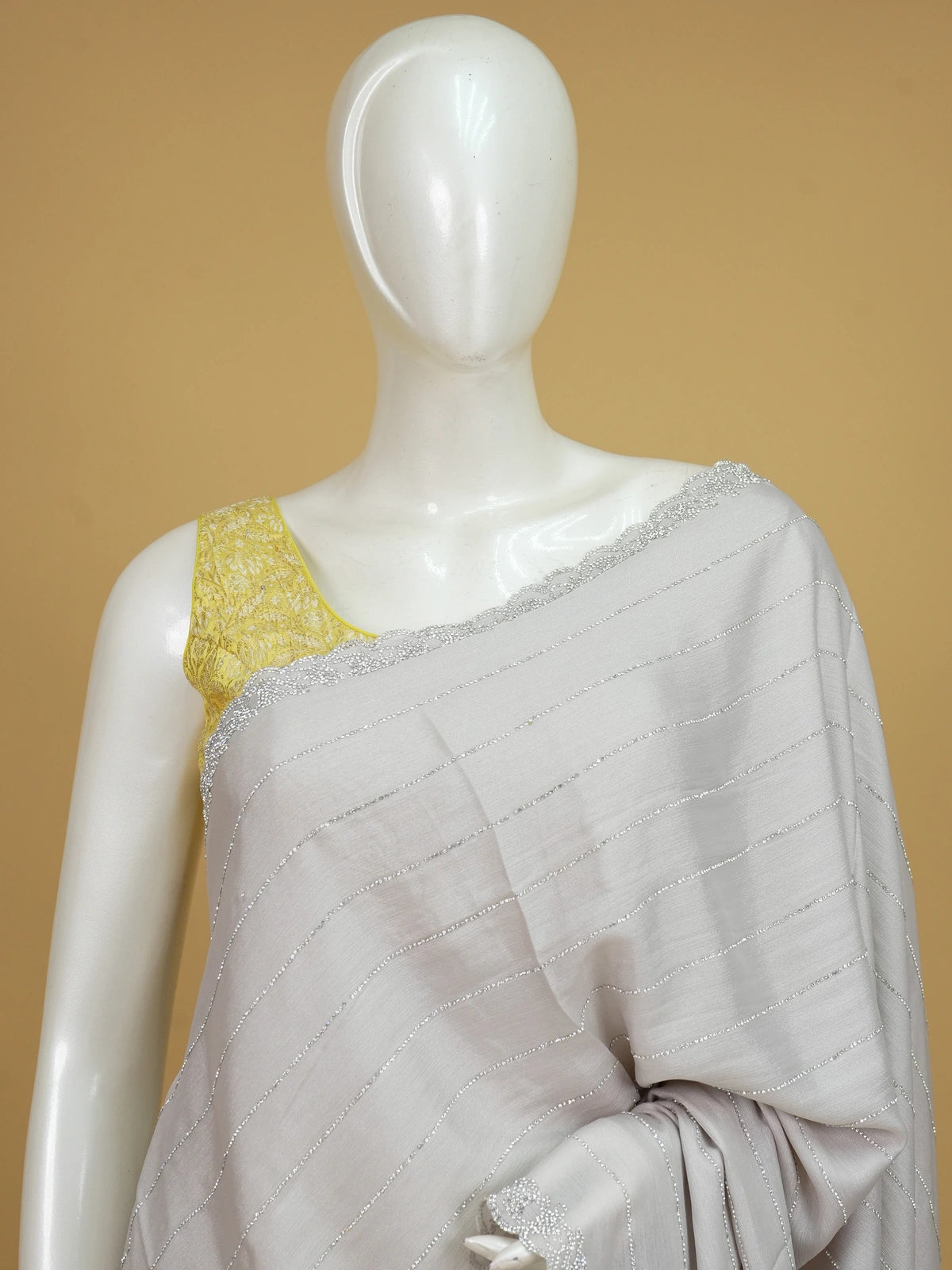 Light grey sheer designer saree with silver stone stripes and scalloped border, styled with a yellow embroidered blouse