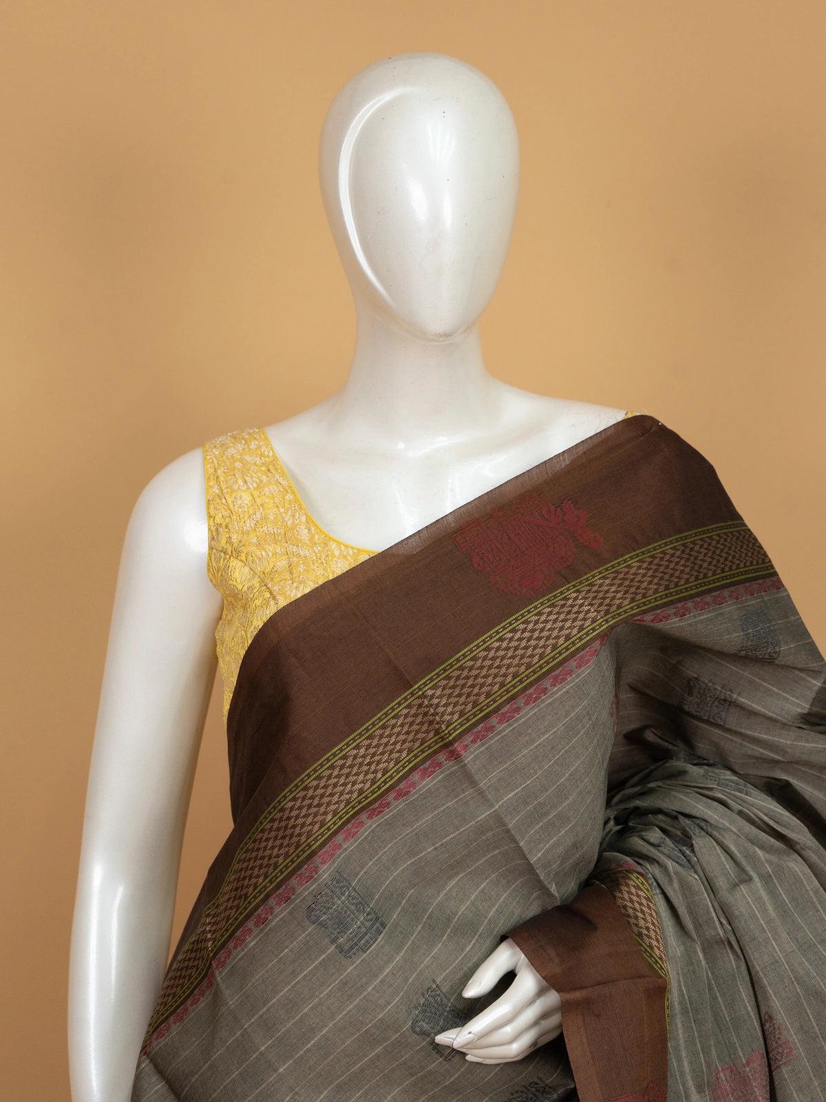 Grey and brown semi raw silk saree with striped body, woven buttas, and contrast temple-motif border
