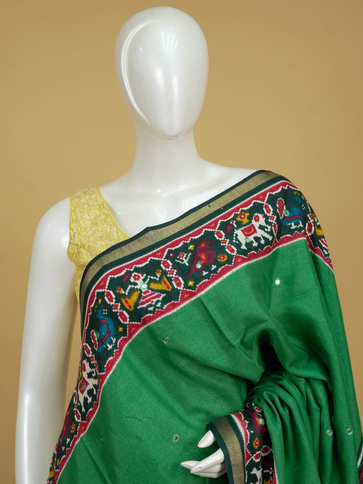 Green linen cotton saree with red patola ikat border, mirror work and multicolour pallu motifs