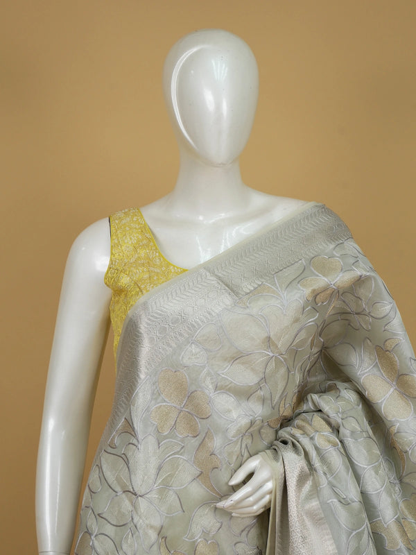 Pastel grey-green organza designer saree with floral embroidery and silver zari border