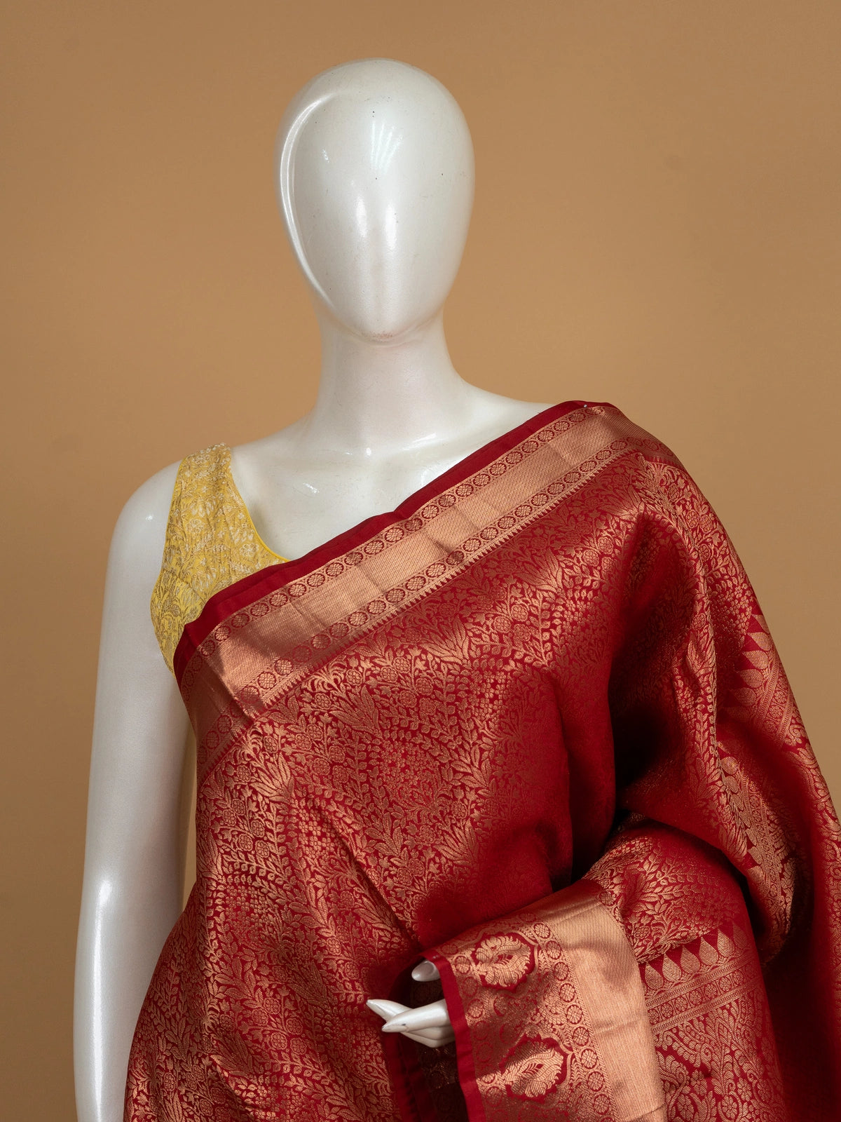 Red pure Kanchipuram silk saree with allover gold zari floral brocade and a broad temple-edged zari border