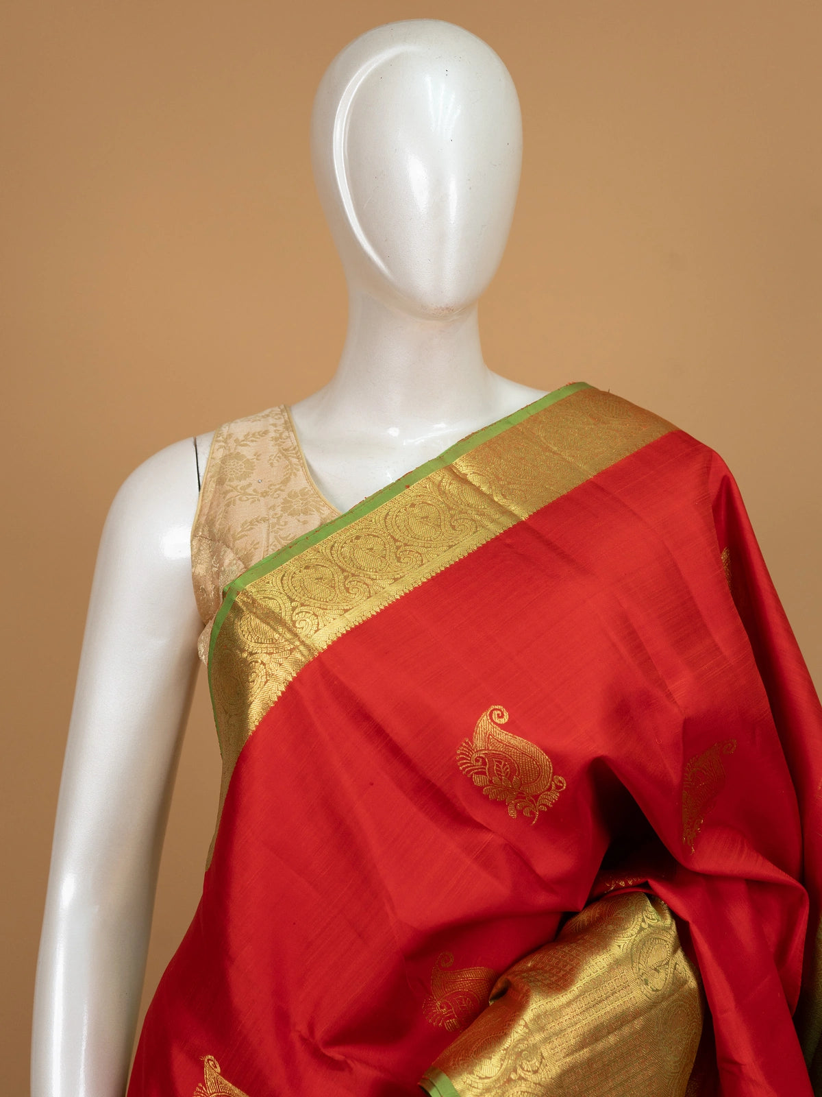 Red pure Kanchipuram silk saree with contrast green and gold zari border and paisley motifs
