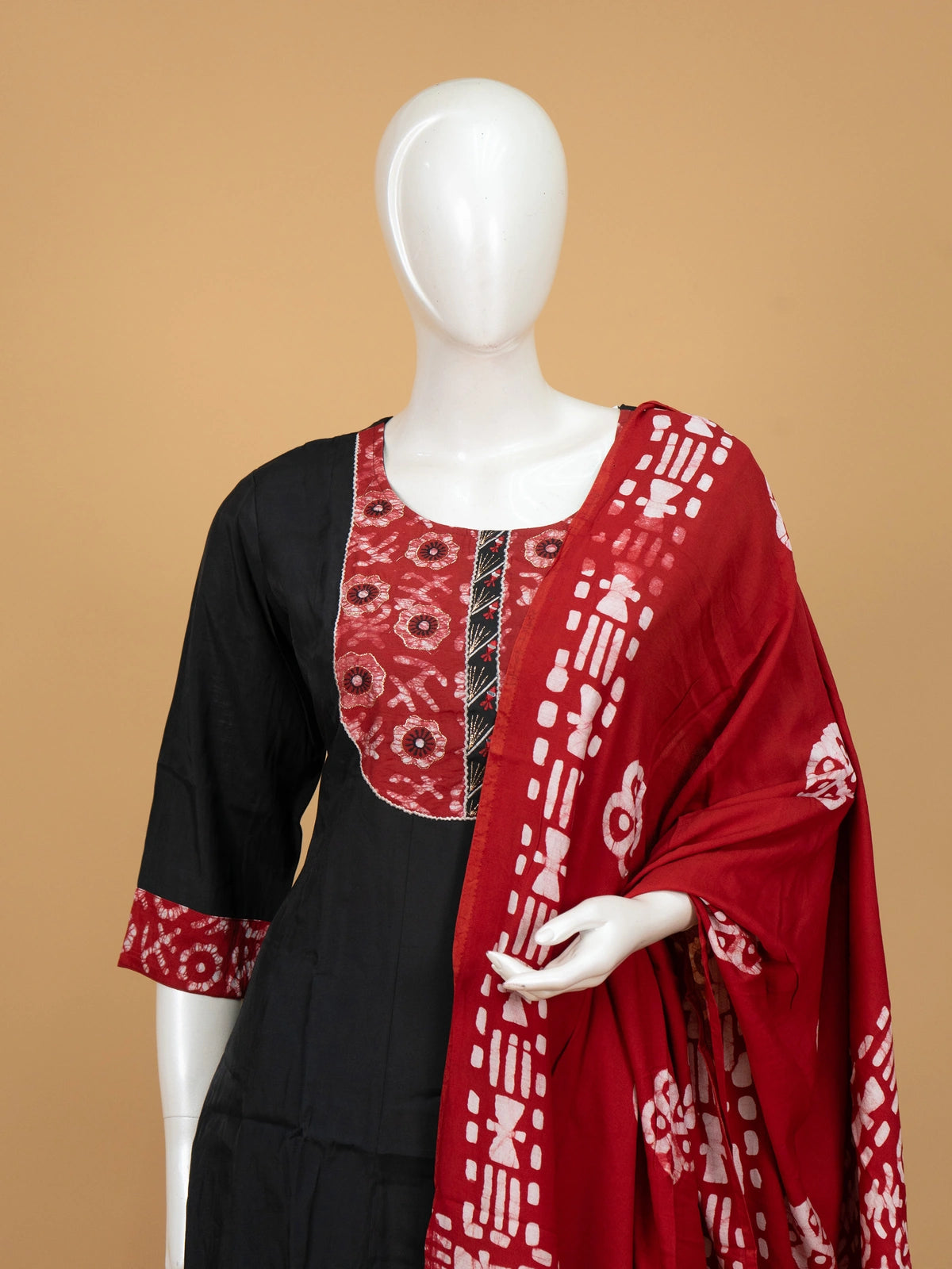 Black A-line cotton kurti set with red batik-print yoke and zari-bordered dupatta