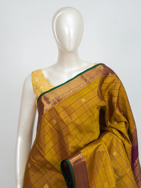 Mustard yellow pure Kanchipuram silk saree with checked body, gold zari buttas and contrast magenta zari border and pallu