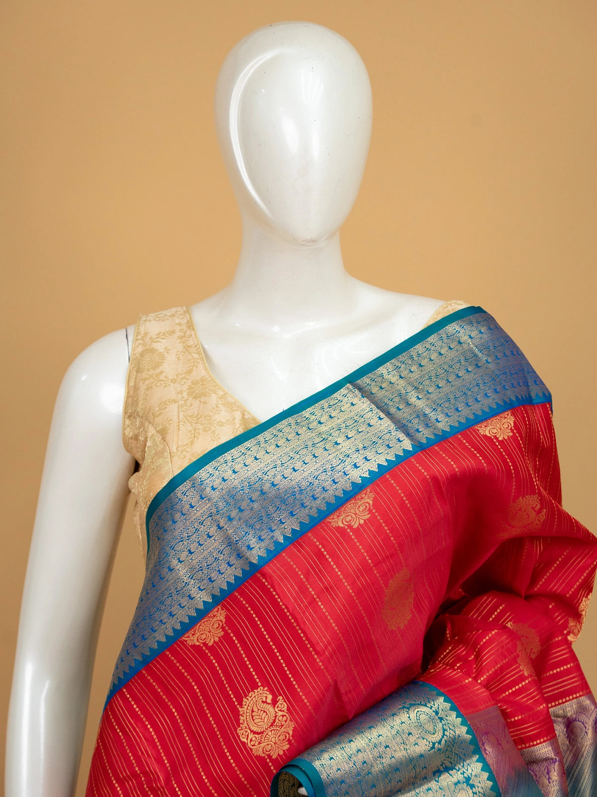 Red pure Kanchipuram silk saree with gold zari buttas and a contrast peacock-blue zari border