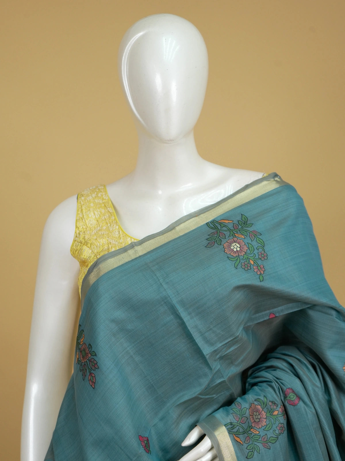 Teal blue linen cotton saree with floral butta body, gold zari border and parrot motif pallu