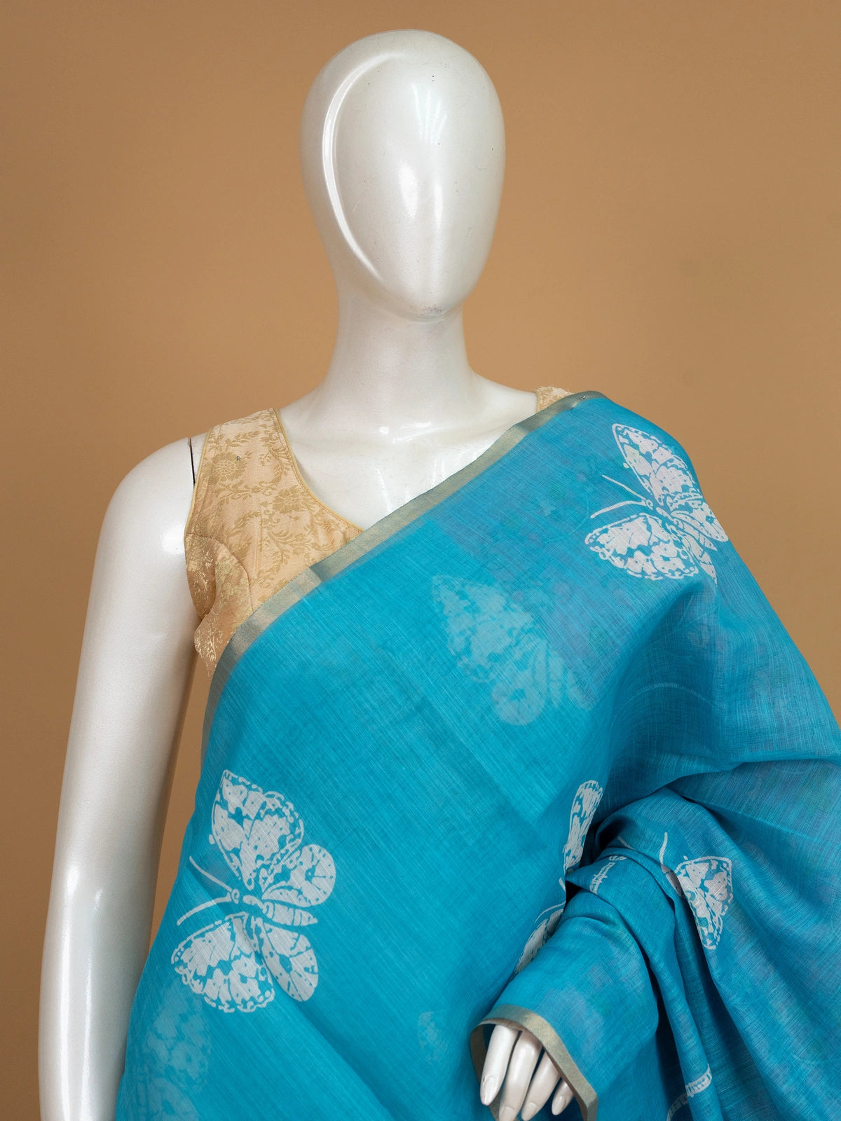 Turquoise blue linen cotton saree with white butterfly prints and a contrast purple Kalamkari pallu