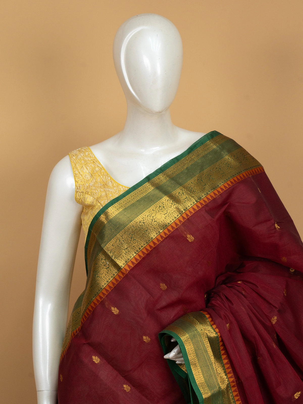Maroon Chettinad cotton saree with green and gold zari contrast border and gold buttas
