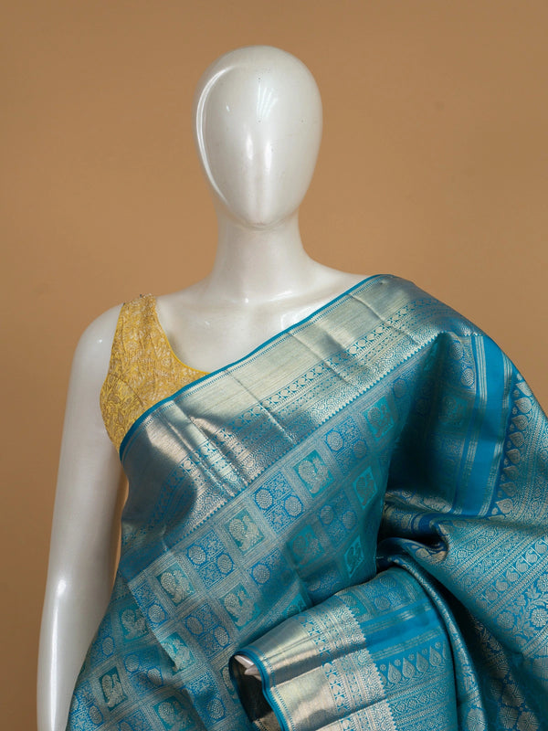 Peacock blue pure Kanchipuram silk saree with silver zari checkerboard motifs, broad zari border and jaali pallu