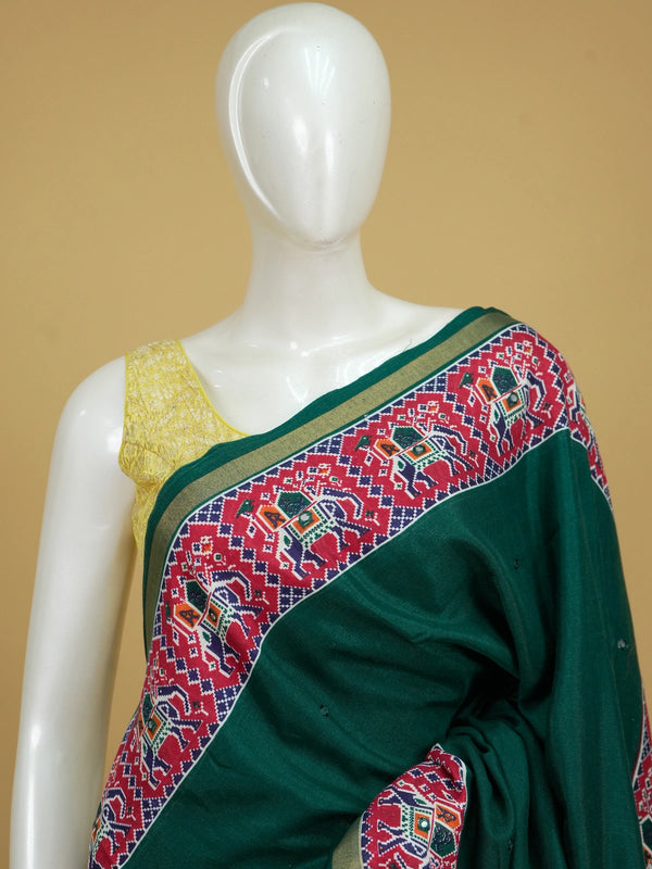Deep green linen cotton saree with red patola-style elephant border and detailed pallu