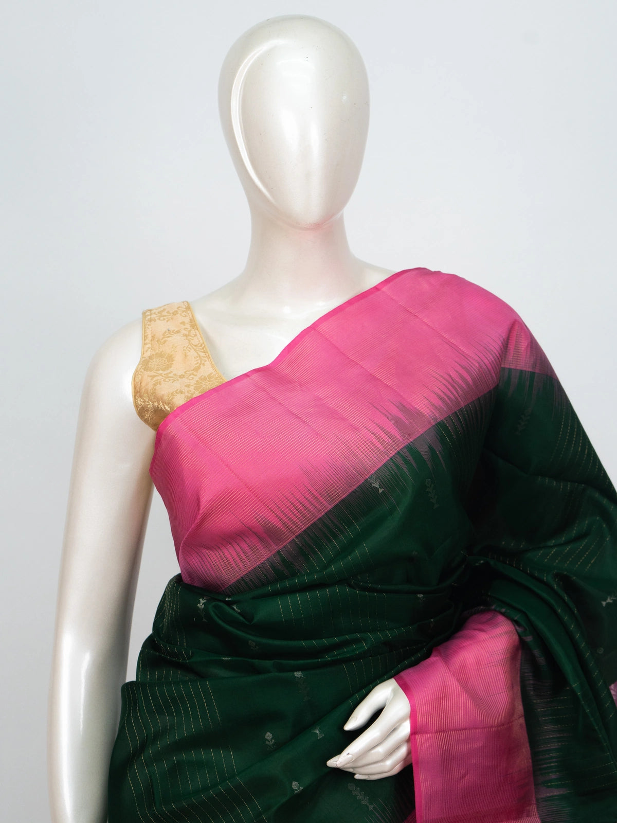 Bottle green soft silk saree with contrast pink zari border and tasselled pallu
