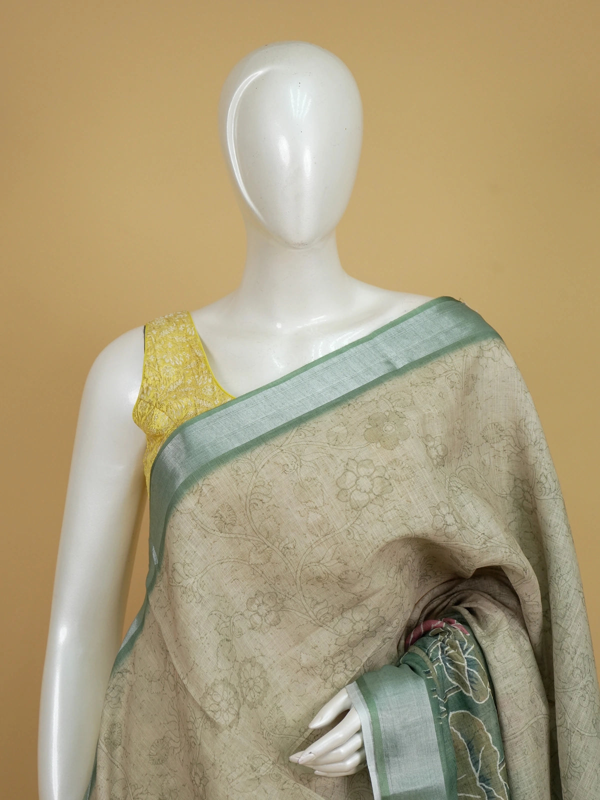 Beige and sage green linen cotton saree with silver zari border and pink lotus print pallu