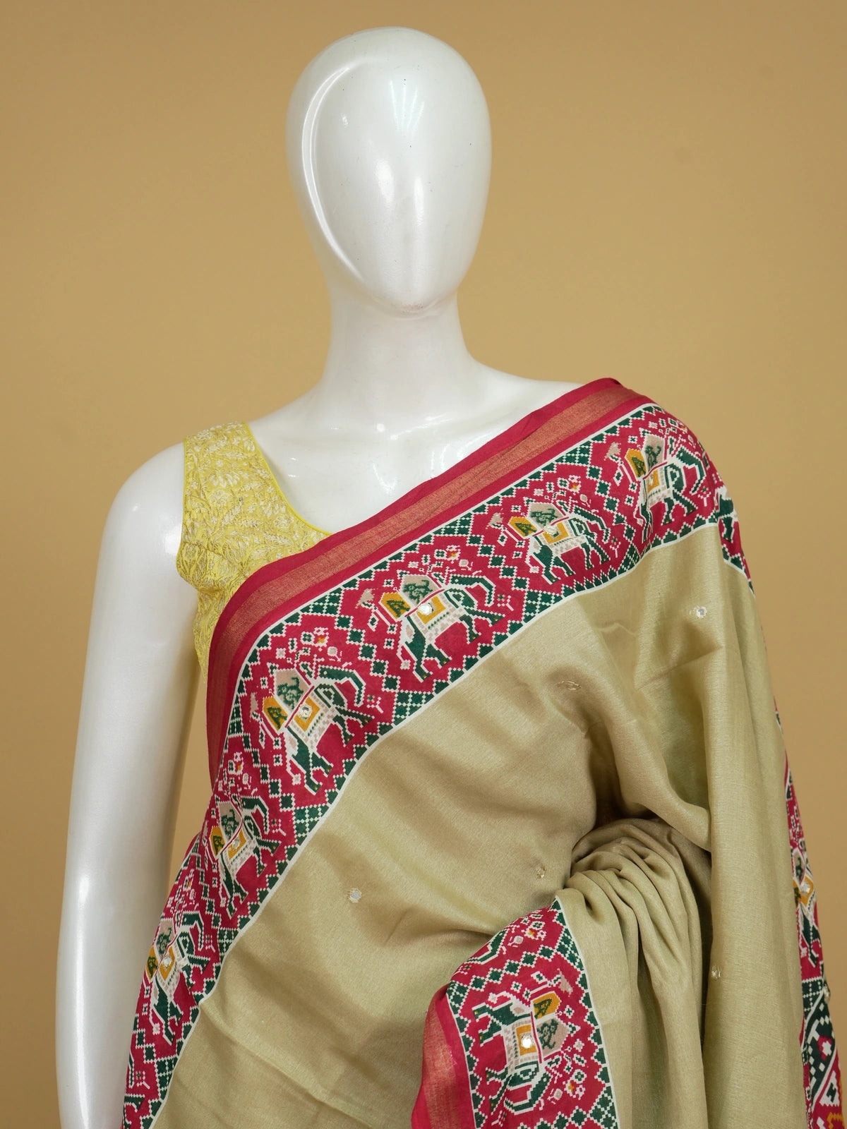 Beige linen cotton saree with red patola-print elephant motif border and pallu