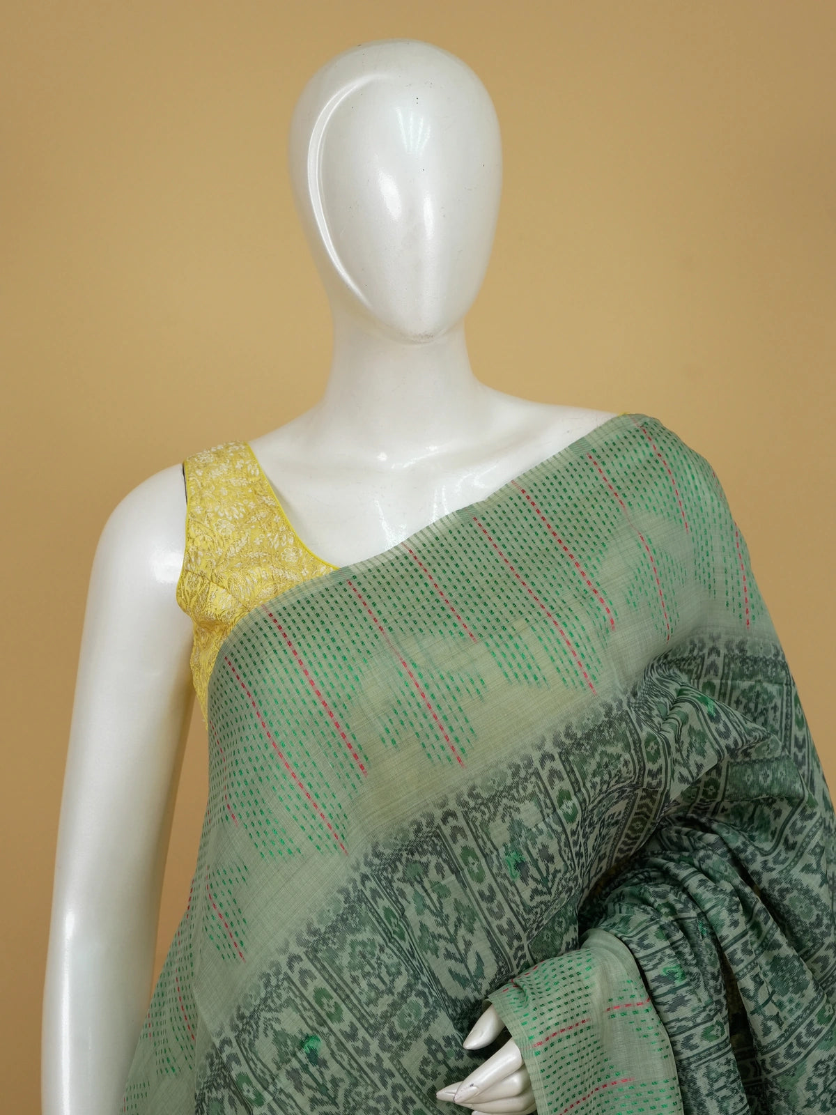 Sage green linen cotton saree with ikat-style motifs and Madhubani bird pallu