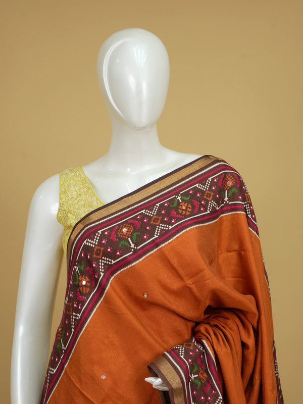 Rust orange linen cotton saree with patola-print brown border, mirror-work buttis and contrast blouse
