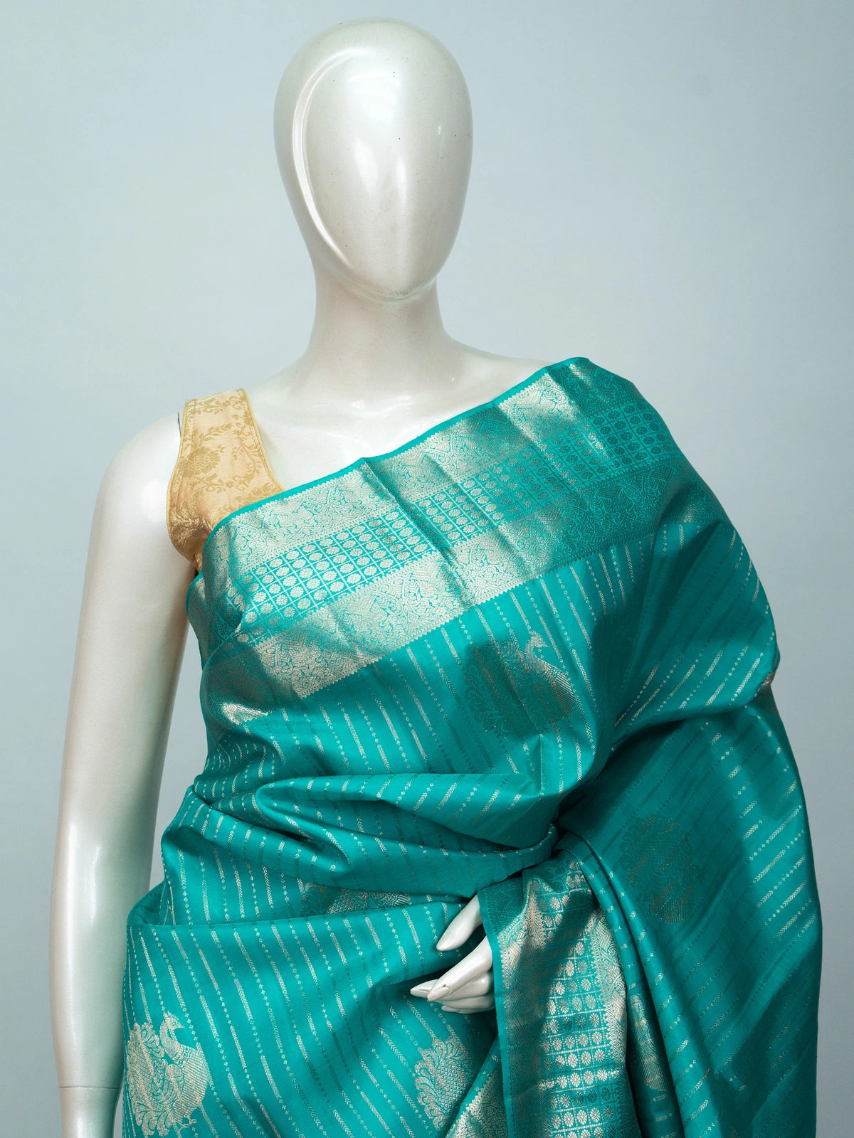 Teal green Pure Kanchipuram silk saree with silver zari diagonal stripes, peacock buttas and a woven zari border