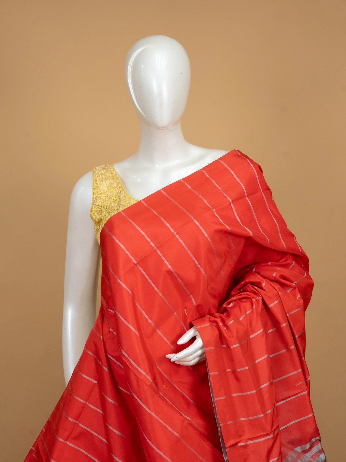 Orange-red banana silk saree with silver zari stripes and a contrast grey-blue pallu