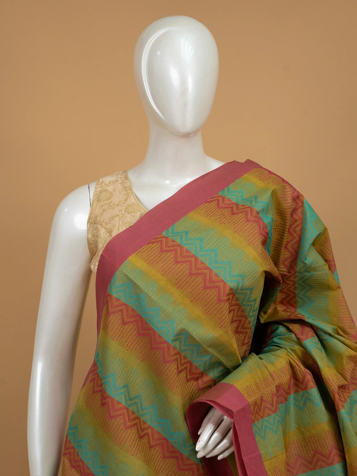 Mustard and pink silk cotton saree with turquoise chevron stripes and floral pallu