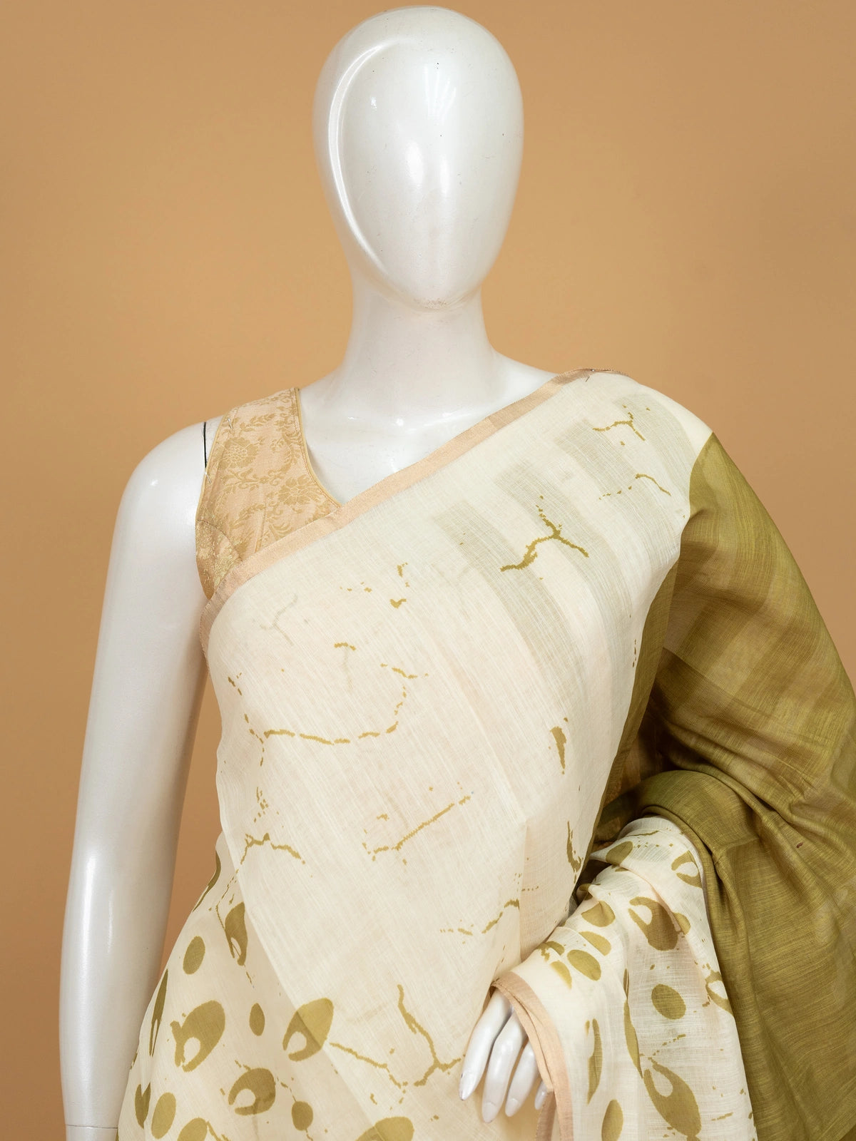 Cream and olive green linen cotton saree with batik-style prints and tree-of-life pallu