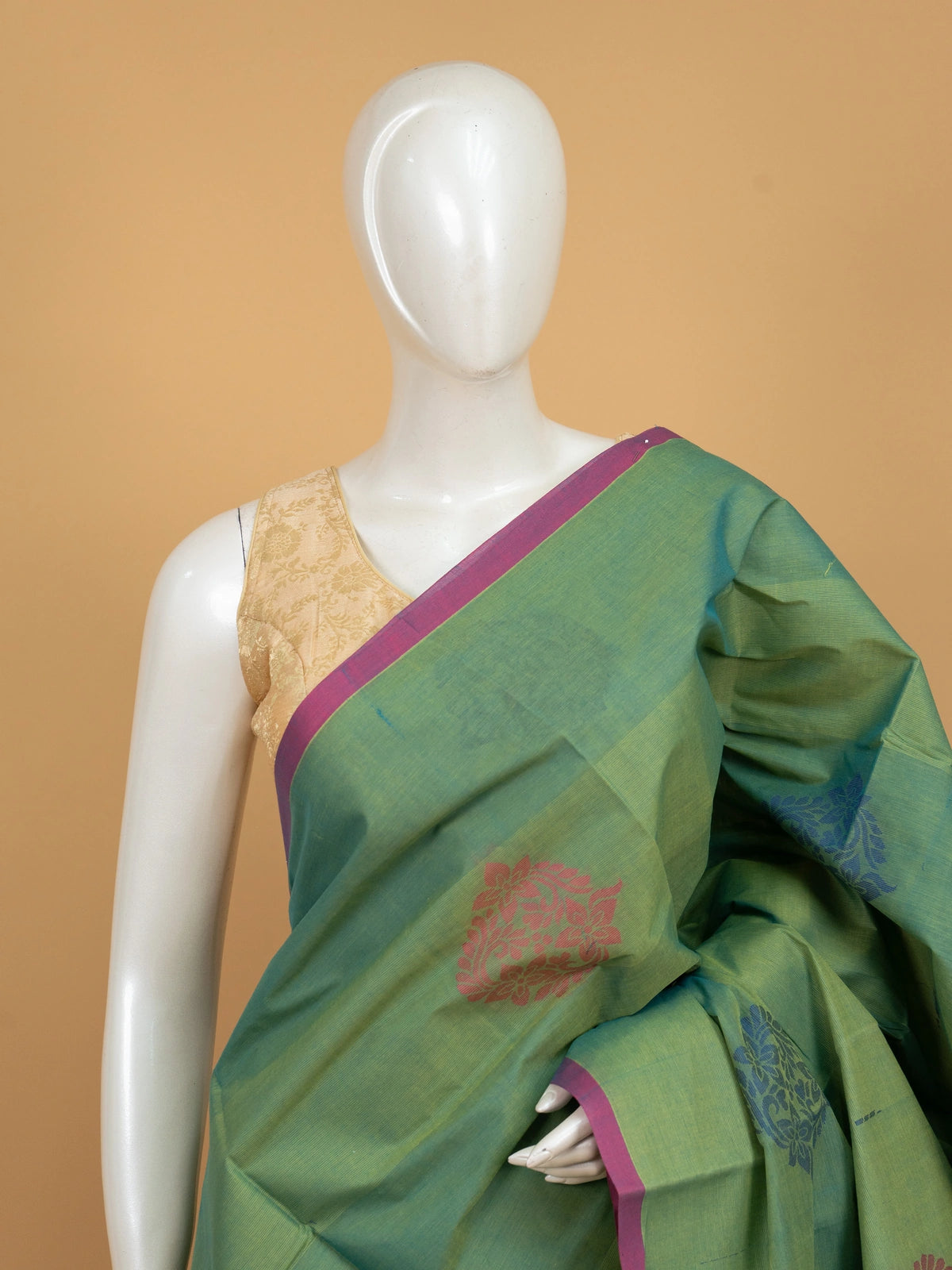 Green silk cotton saree with contrast pink border and pink and blue floral butta motifs