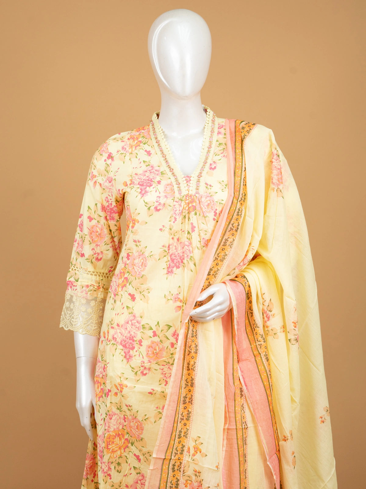 Yellow floral cotton Anarkali kurti set with beaded V-neck, lace cuffs, straight pants, and pink-bordered dupatta