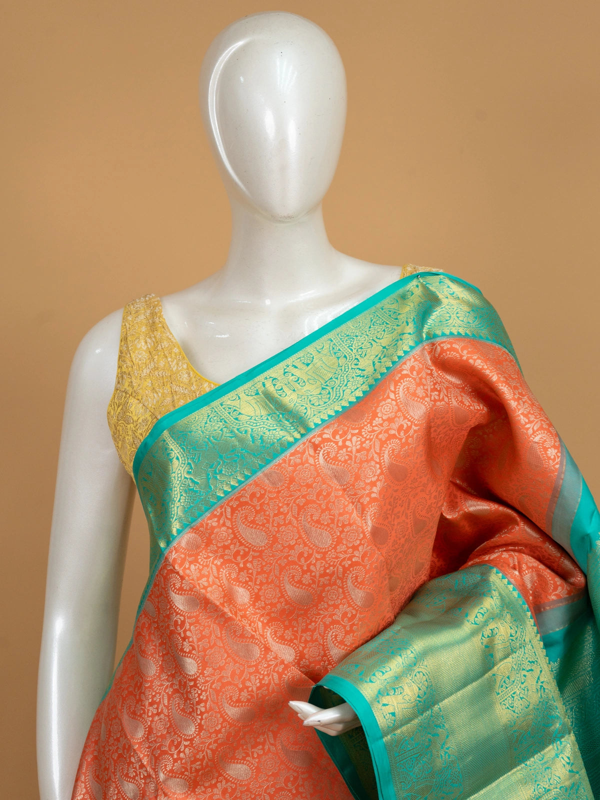 Coral orange pure Kanchipuram silk saree with teal green gold zari elephant border and matching blouse