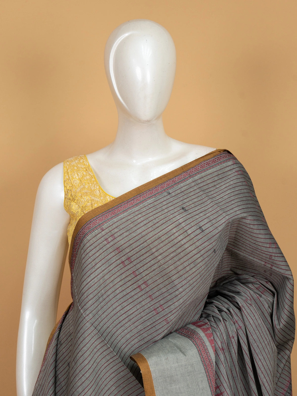 Grey linen cotton saree with maroon pinstripes, mustard contrast border, and paisley woven pallu