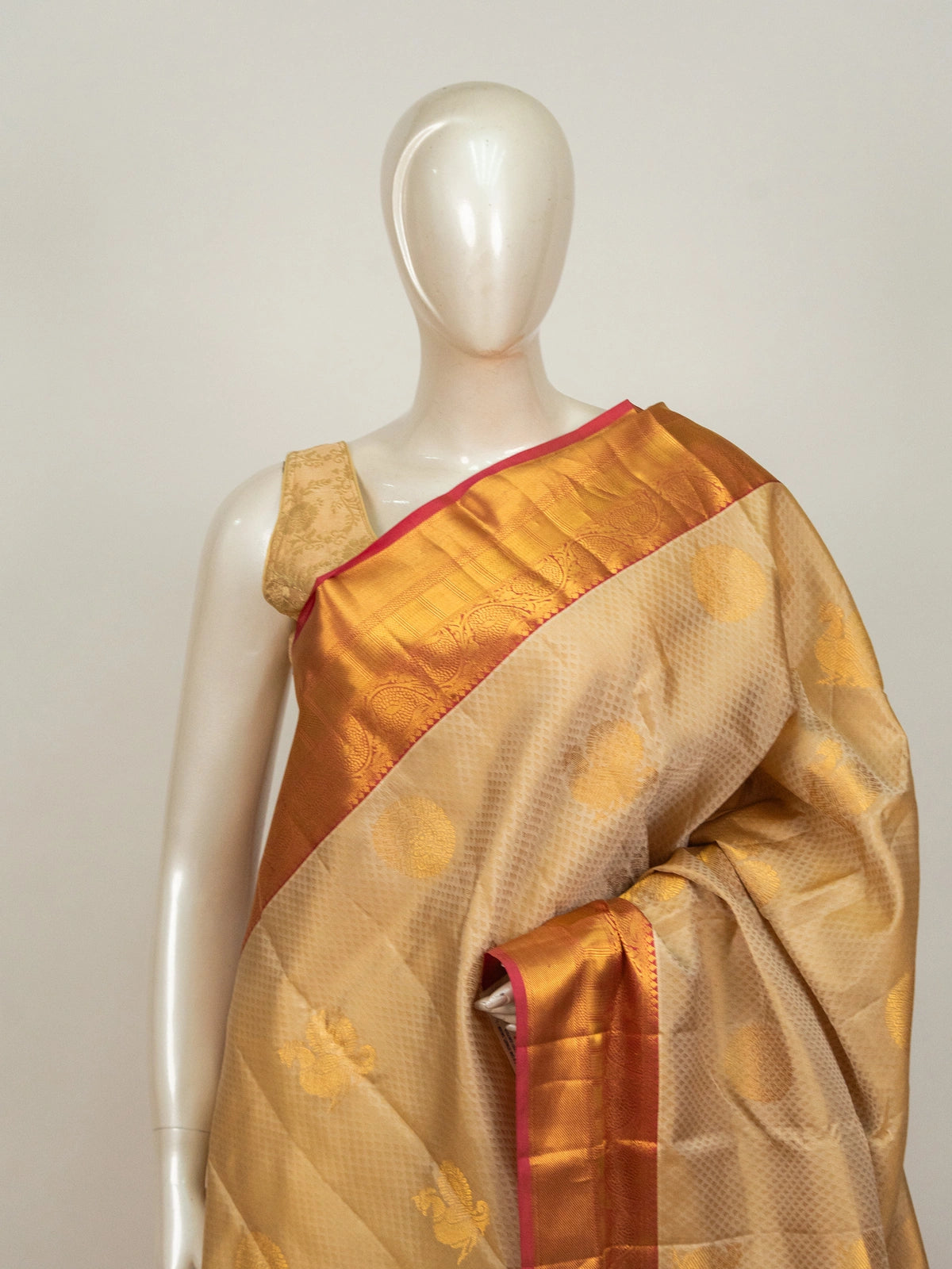 Cream pure Kanchipuram silk saree with gold zari buttas and contrast orange-red zari border