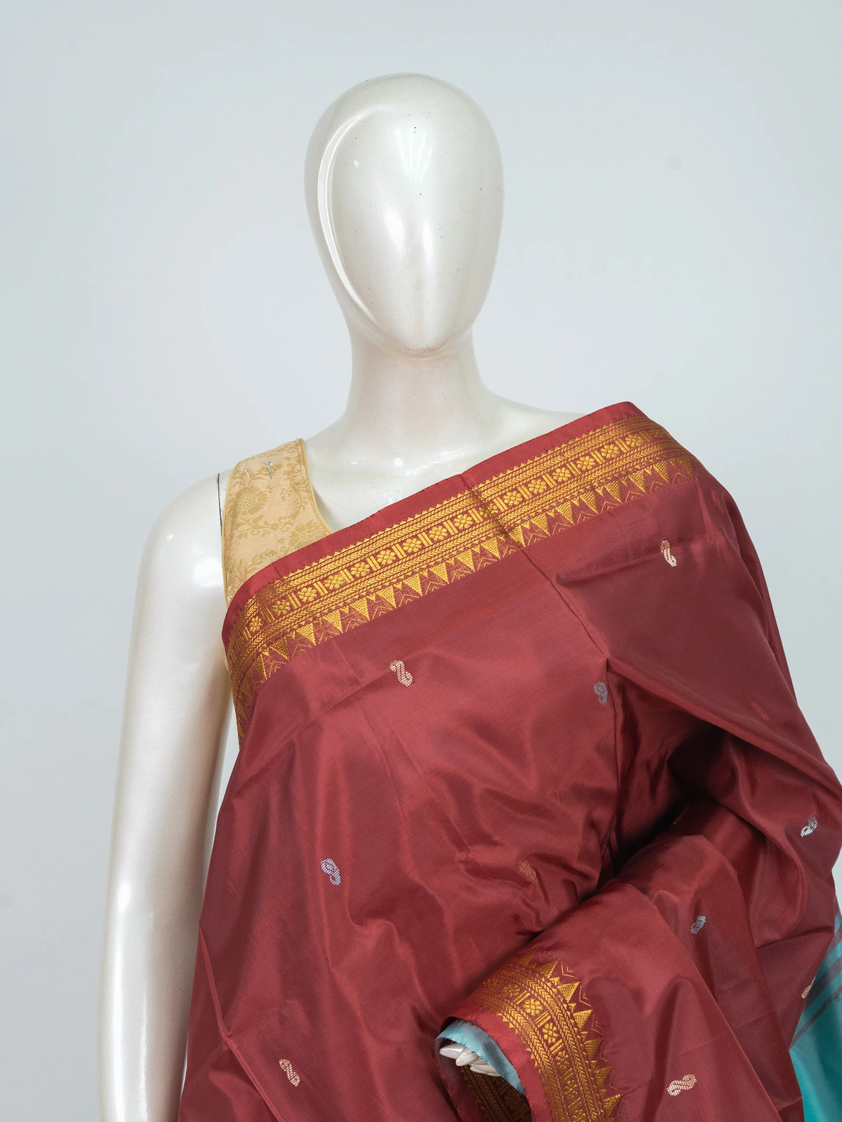 Maroon Banana Silk saree with turquoise contrast pallu and gold zari temple border
