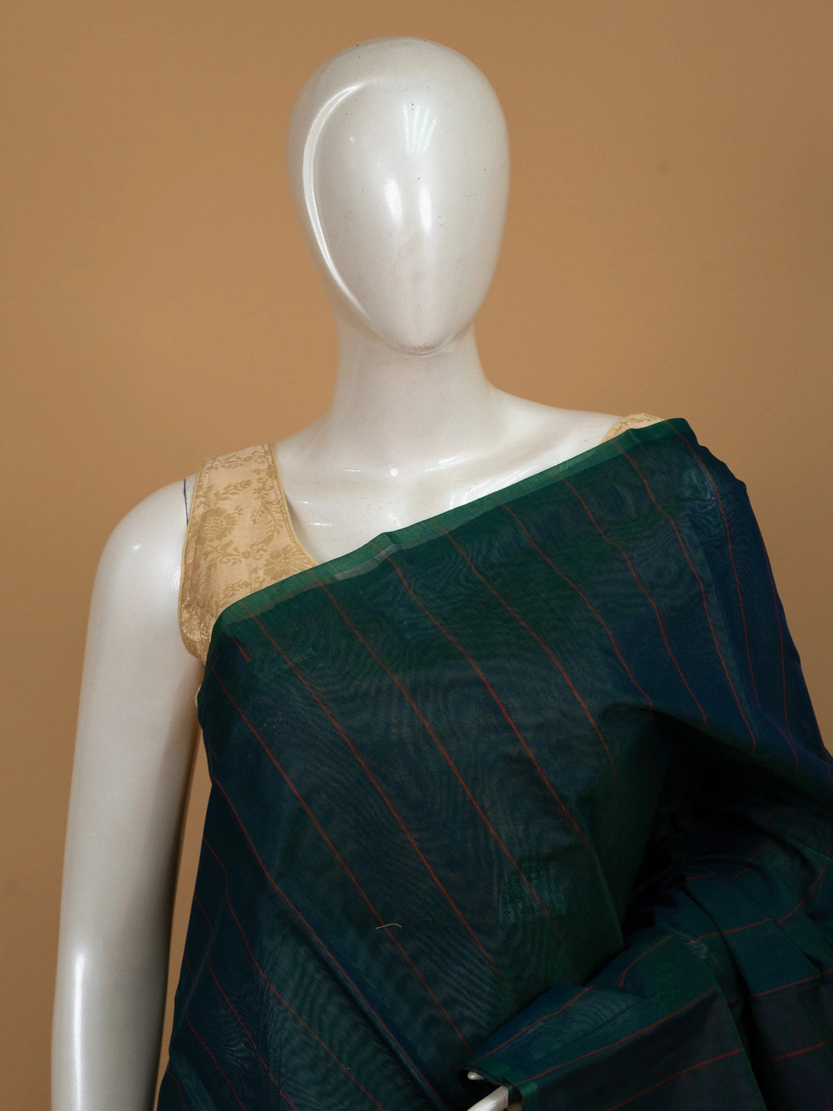 Teal green silk cotton saree with maroon stripes and contrast striped pallu on mannequin