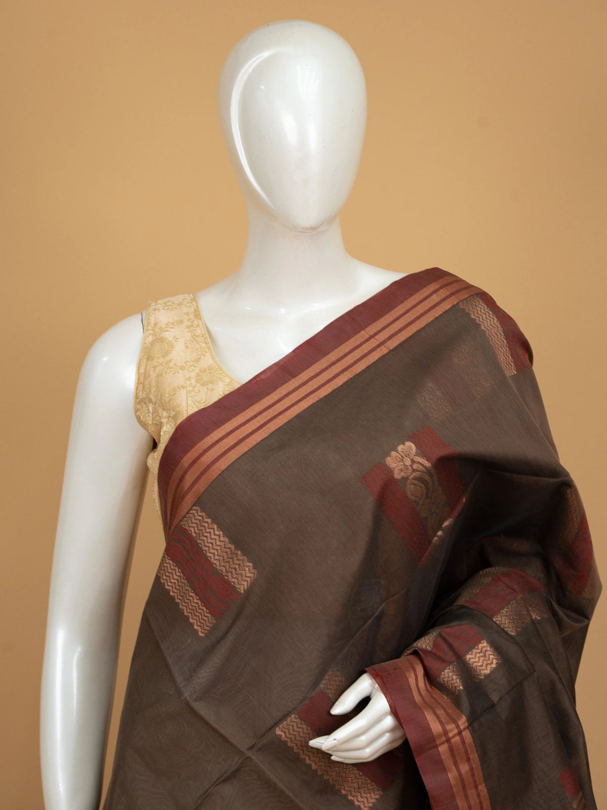 Brown silk cotton saree with contrast maroon border and copper zari butta motifs