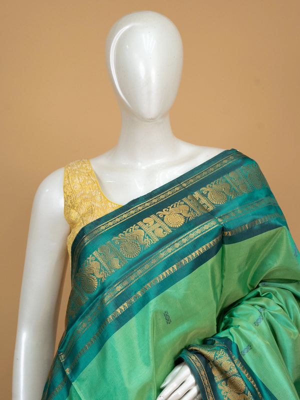 Green banana silk saree with teal gold zari peacock border and contrast maroon pallu