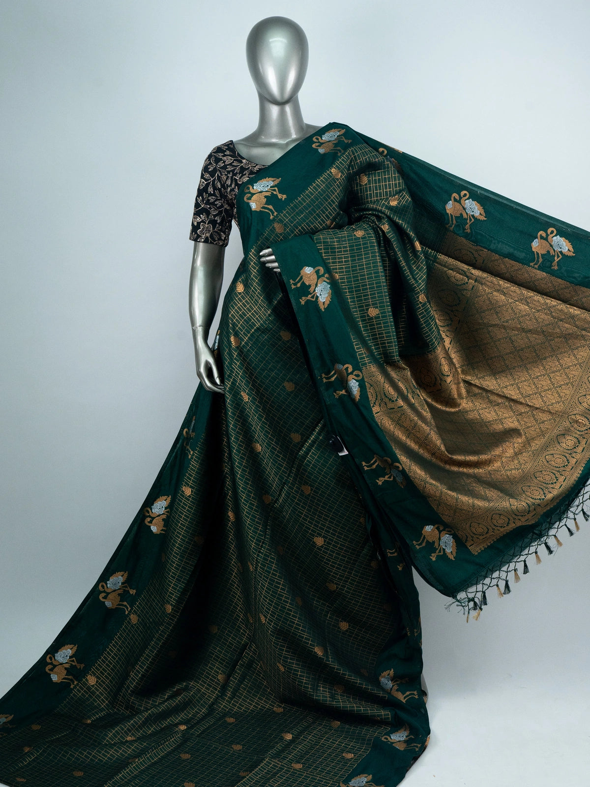 Bottle green semi raw silk saree with gold zari checks, yali motifs and contrast black embroidered blouse