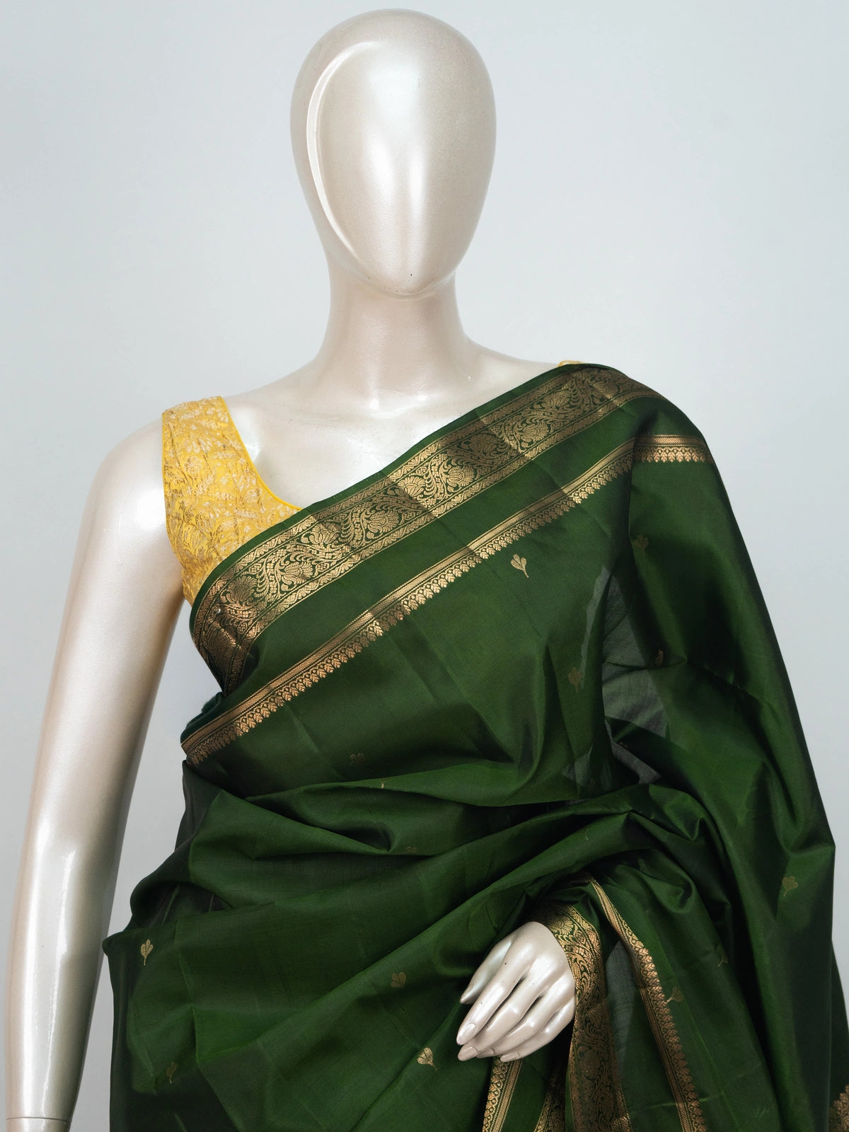 Dark green soft silk saree with gold zari floral border and buttis