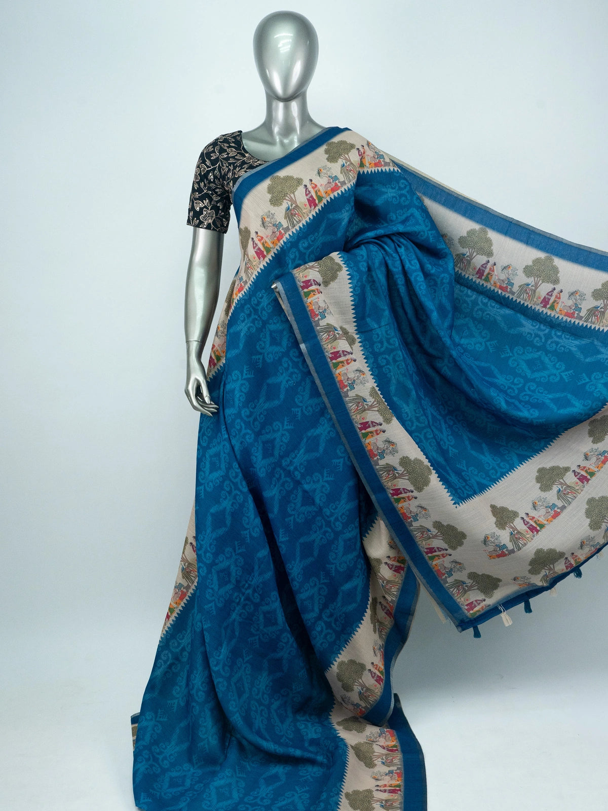 Peacock blue linen cotton saree with cream folk-art border and pallu featuring trees, figures and peacocks