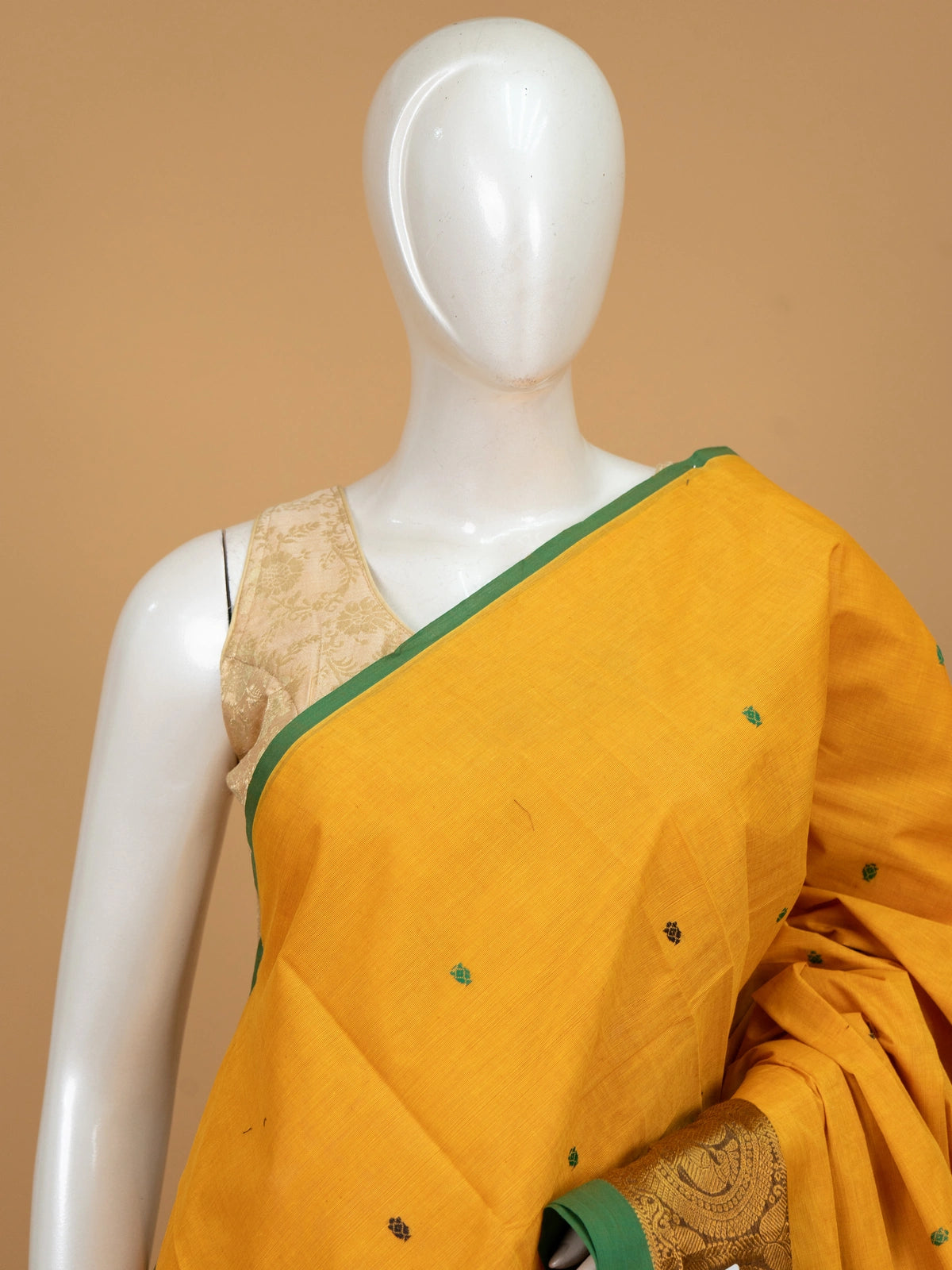 Mustard yellow Chettinad cotton saree with green contrast border, gold zari peacock motifs and woven buttis