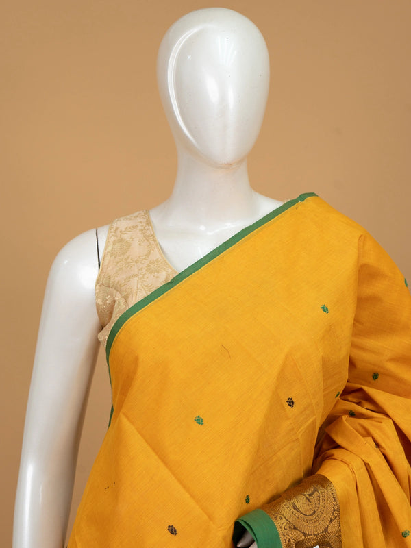Mustard yellow Chettinad cotton saree with green contrast border, gold zari peacock motifs and woven buttis