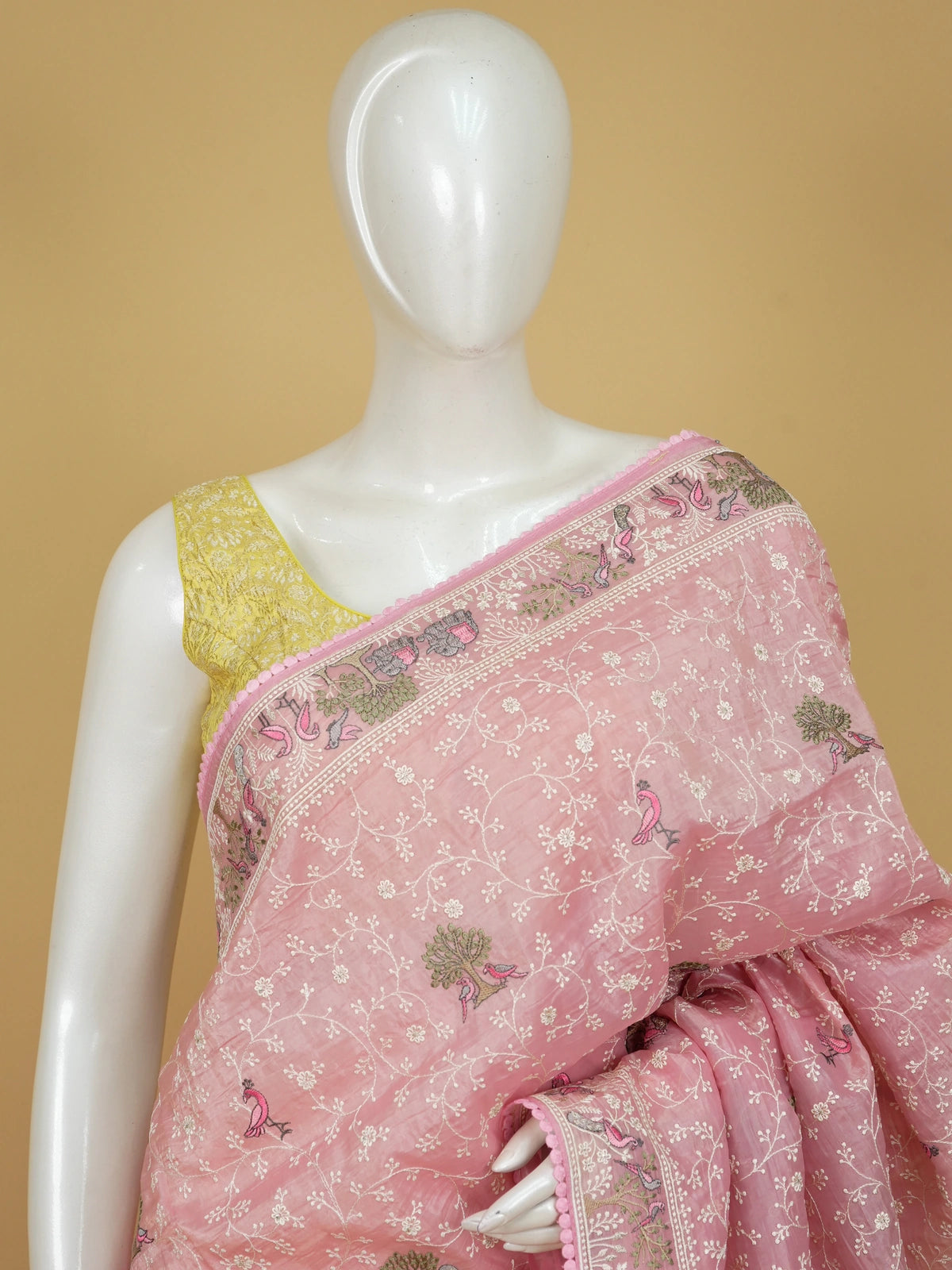 Pastel pink embroidered designer saree with floral jaal, bird and elephant motifs and pom-pom border