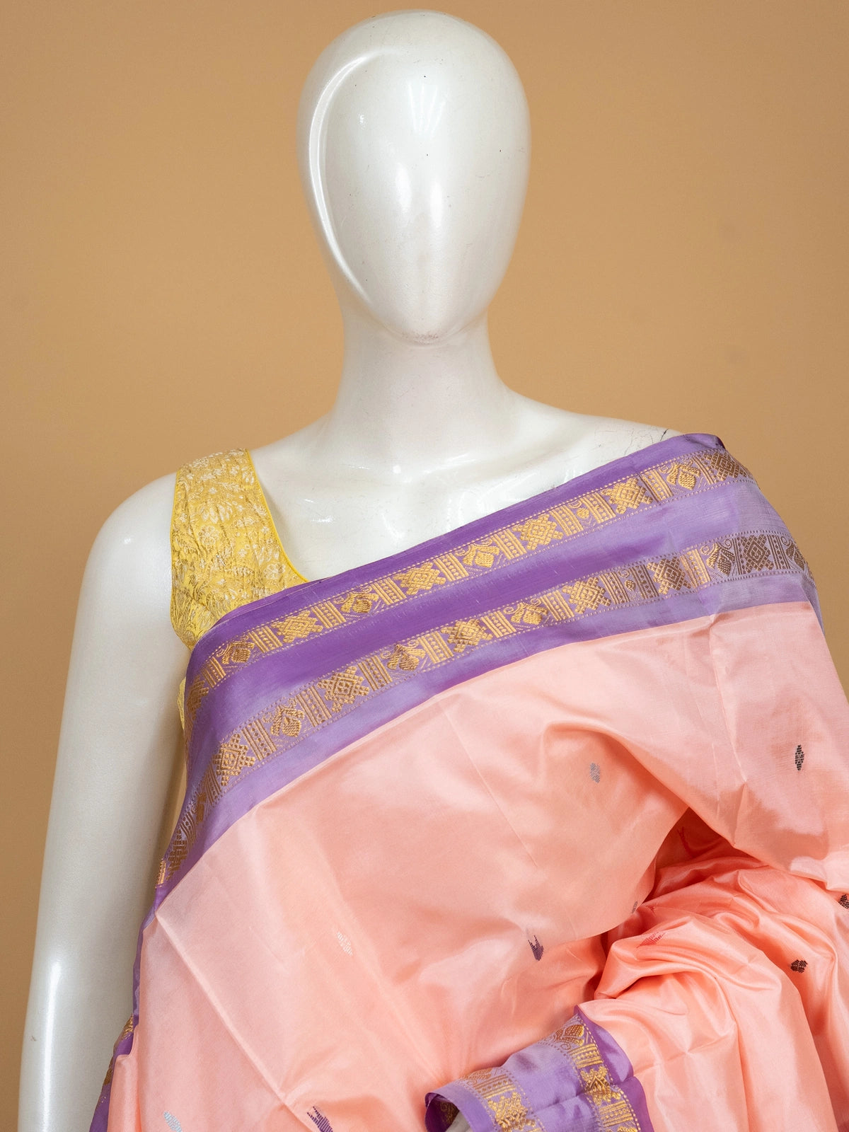 Peach banana silk saree with purple contrast border and gold zari pallu