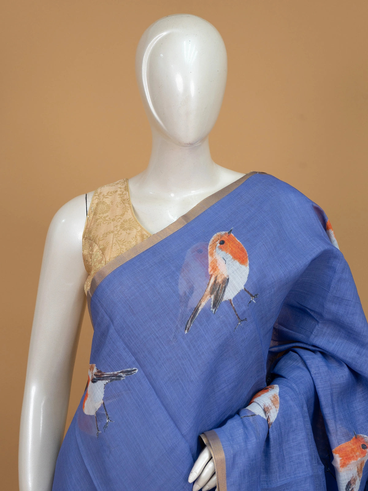 Periwinkle blue linen cotton saree with orange and white robin bird prints and a gold zari border