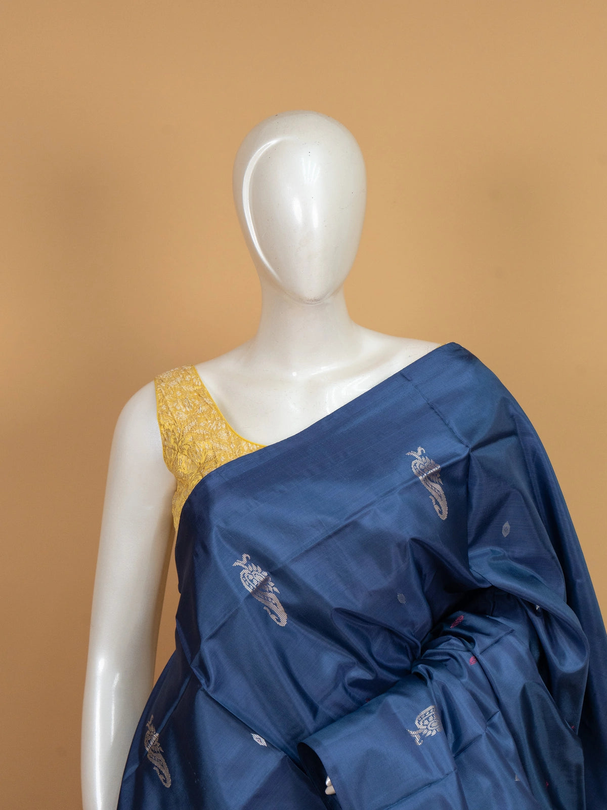 Navy blue banana silk saree with mustard contrast pallu and silver zari peacock buttas