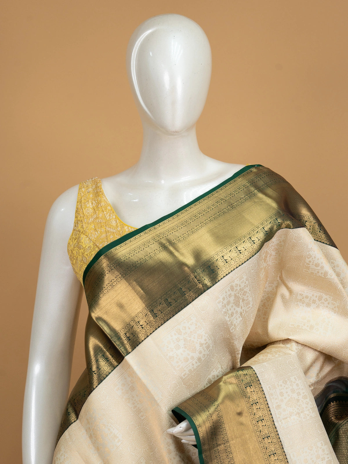 Cream pure Kanchipuram silk saree with gold zari brocade body and contrast dark green and gold border and pallu