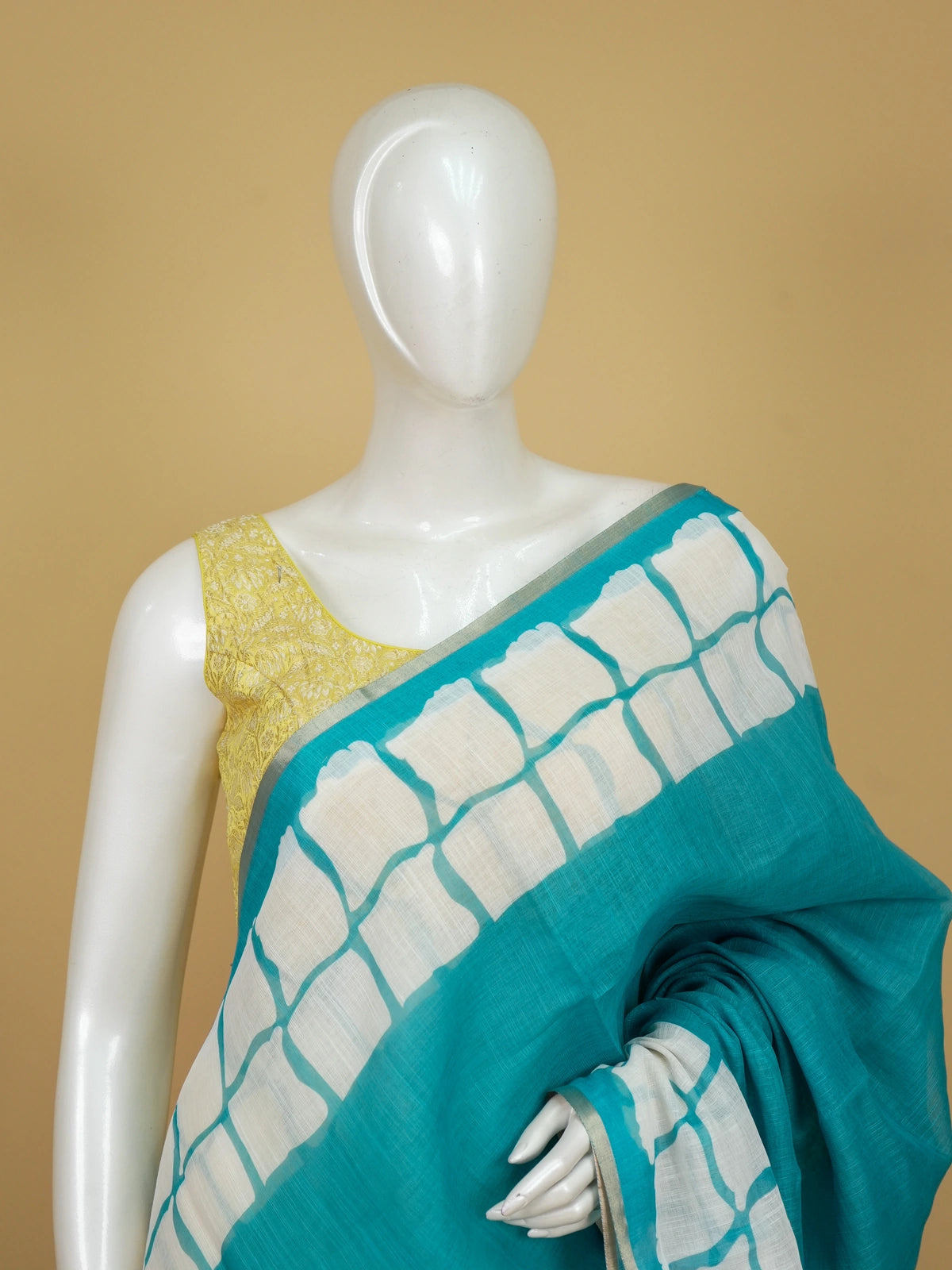 Teal and off-white linen cotton saree with batik grid border and white spiral motifs