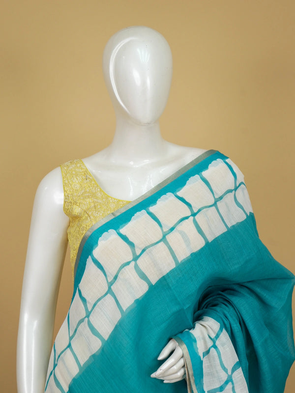 Teal and off-white linen cotton saree with batik grid border and white spiral motifs