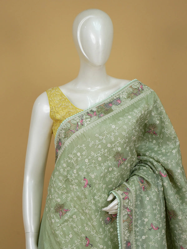 Sage green designer saree with white floral embroidery, pink bird and elephant motifs and pom-pom lace border