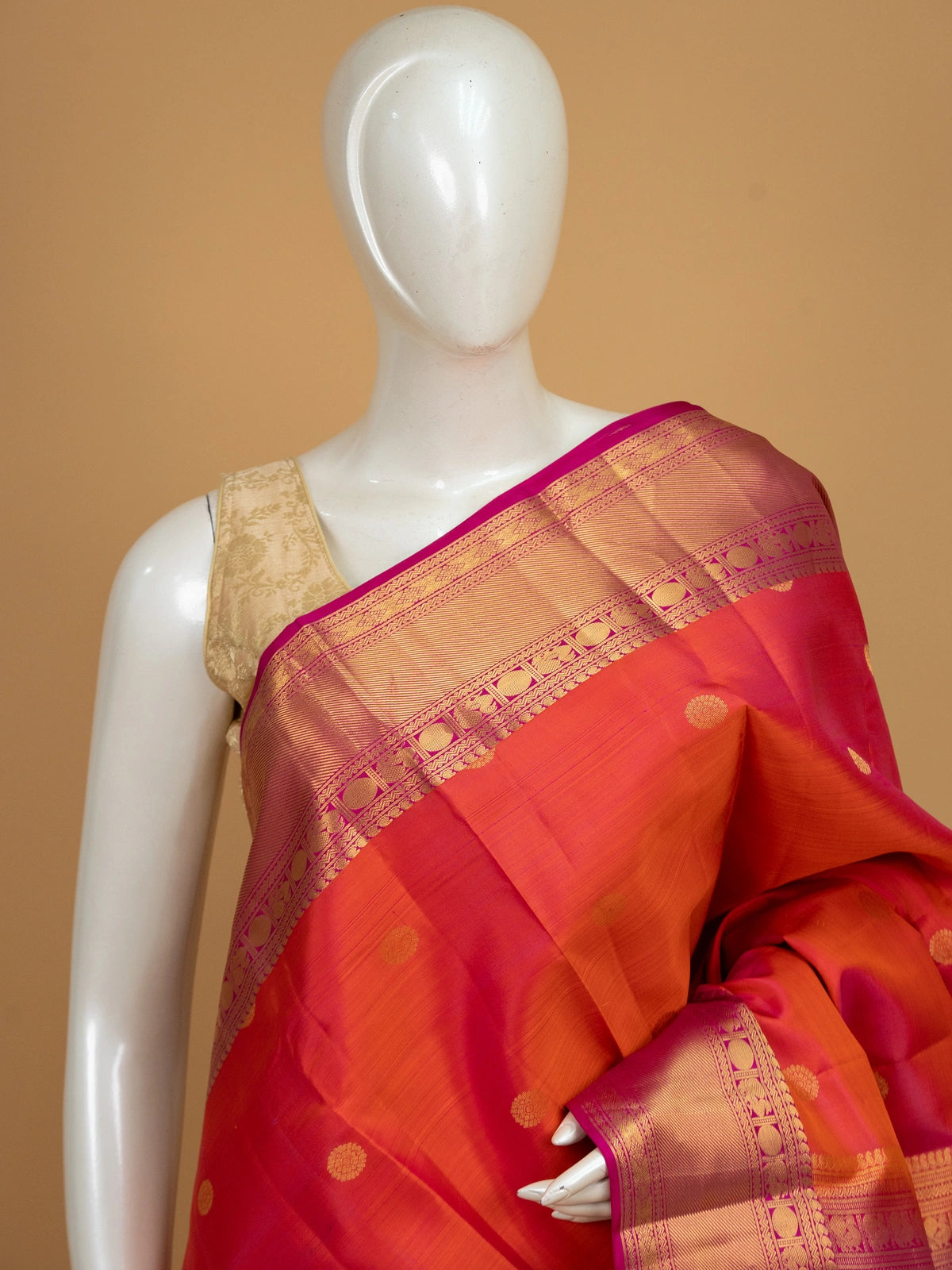 Orange pure Kanchipuram silk saree with contrast pink border and gold zari buttas
